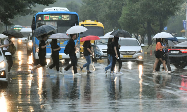 올해 첫 장맛비가 내린 26일 우산을 쓴 시민들이 창원시 의창구 은아아파트 사거리 횡단보도를 걷고 있다./전강용 기자/