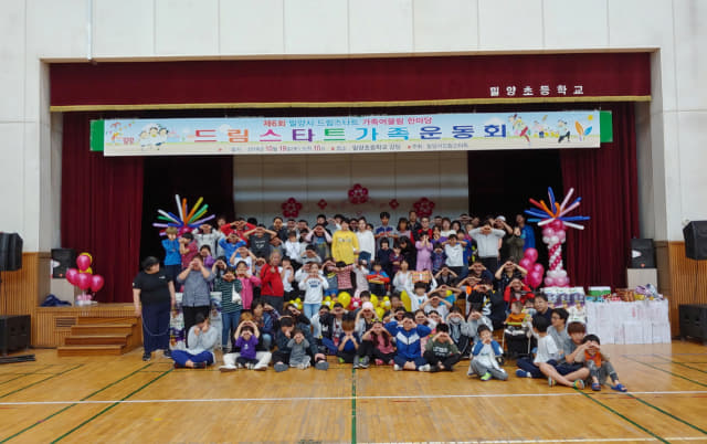 19일 밀양초등학교 강당에서 열린 ‘드림스타트 가족운동회’에서 드림스타트 아동과 가족 150여 명이 단체사진을 찍고 있다.