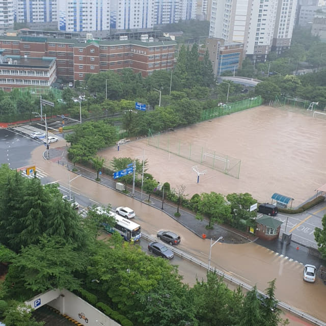 시간당 최대 50㎜ 이상의 비가 내린 10일 부산 해운대구 신시가지 도로가 흙탕물이 넘쳐흐르고 있다. 연합뉴스