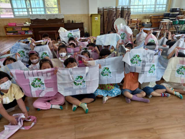 진주시의 맞춤형 환경교육 프로그램인 ‘찾아가는 자원순환교실’에 참여한 어린이들이 폐현수막 장바구니를 들어보이고 있다./진주시/