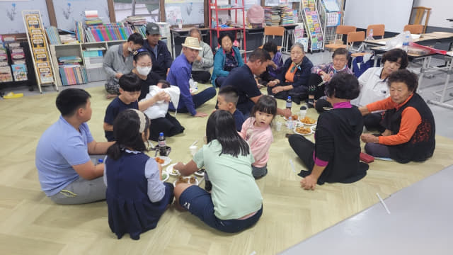 금바실학당에서 마을 어르신들과 아이들이 간식을 먹고 있다./김성웅 이장/