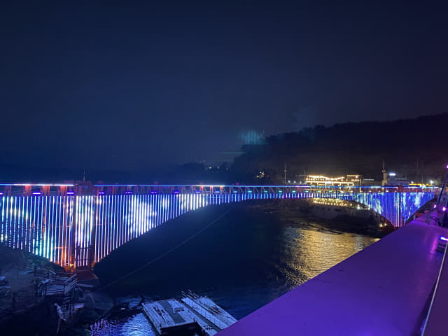 창원 마산합포구 구산면에 있는 저도 콰이강의 다리, 미디어 영상을 보여주는 미디어파사드가 형형색색 매력을 뽐내며 밤하늘을 수놓고 있다.