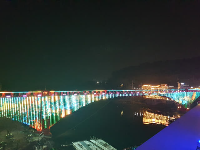 창원 마산합포구 구산면에 있는 저도 콰이강의 다리, 미디어 영상을 보여주는 미디어파사드가 형형색색 매력을 뽐내며 밤하늘을 수놓고 있다.